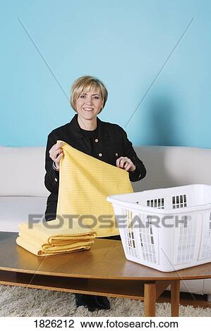 Woman folding laundry View Large Photo Image Stock Image - Woman folding laundry. Fotosearch