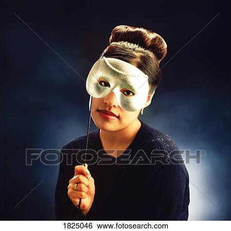 Stock Photograph - Woman holding mask over eyes. Fotosearch