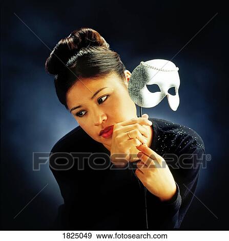 Stock Photo - Woman holding mask. Fotosearch