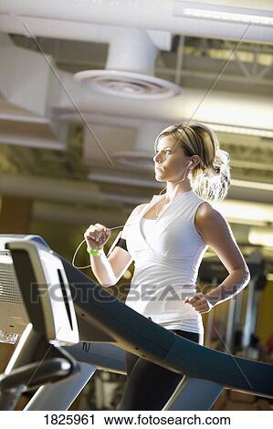 Woman running on a treadmill View Large Photo Image Stock Image - Woman running on a treadmill. Fotosearch
