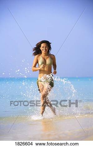 Picture - Woman running on the beach, Playa del Carmen, Mayan Riviera, Mexico. Fotosearch