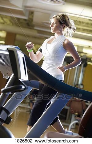 Stock Image - Woman running on treadmill. Fotosearch
