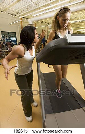 Woman running on treadmill with pressure from trainer View Large Photo Image Stock Image - Woman running on treadmill with pressure from trainer. Fotosearch