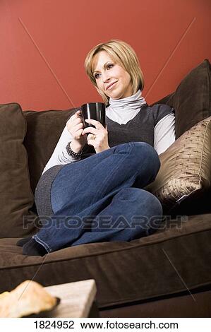 Woman sitting on sofa View Large Photo Image Stock Image - Woman sitting on sofa. Fotosearch