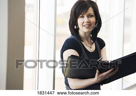 Woman with a head set writing in her book View Large Photo Image Stock Photo - Woman with a head set writing in her book. Fotosearch