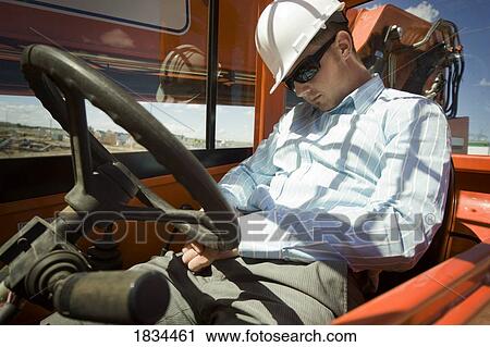 Stock Image - Worker asleep on the job. Fotosearch