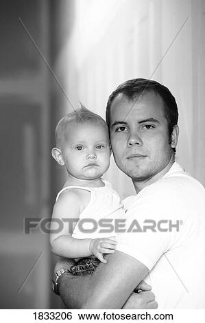 Stock Photograph - Young father holding his baby daughter. Fotosearch
