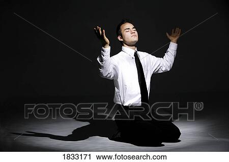Young man praying on his knees View Large Photo Image Stock Image - Young man praying on his knees. Fotosearch