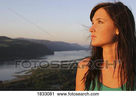 Stock Image - Young woman looking up. Fotosearch