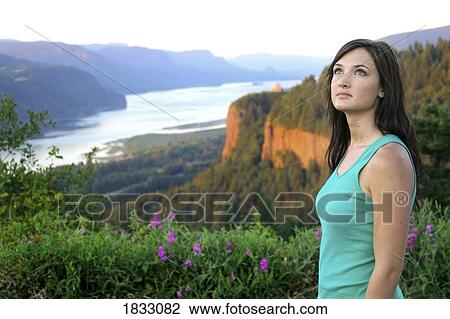Stock Image - Young woman looking up. Fotosearch