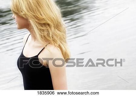 Stock Photograph - Blond woman by water. Fotosearch