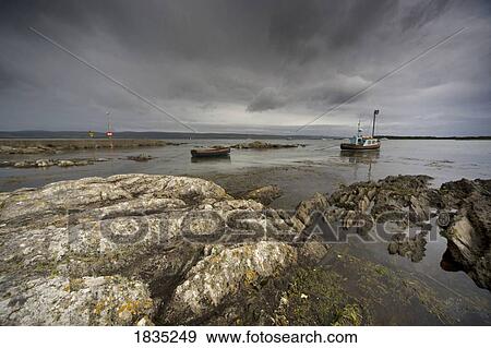Stock Photo - Boat in water and stormy sky. Fotosearch