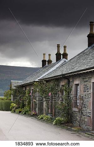 Stock Image - Buildings under storm clouds, Scotland. Fotosearch