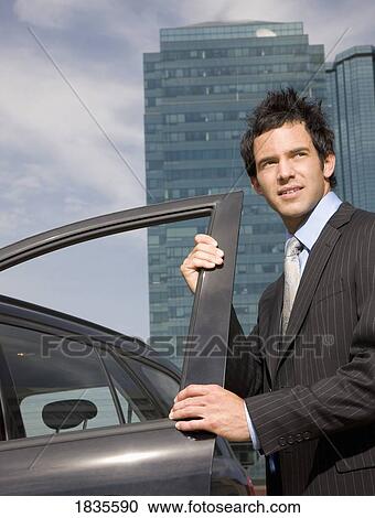 Stock Image - Businessman getting in car. Fotosearch