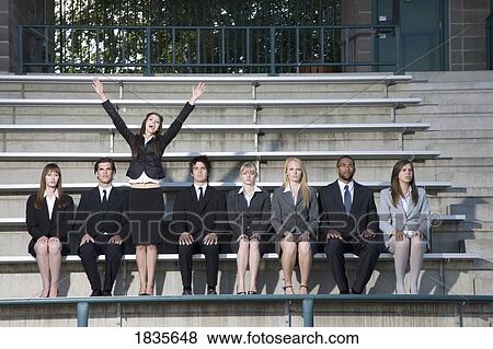 Businesswoman cheering in the stands among unmoving business people View Large Photo Image Stock Photo - Businesswoman cheering in the stands among unmoving business people. Fotosearch