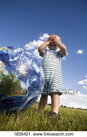 Stock Image - Child playing with ball. Fotosearch