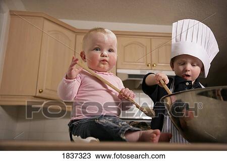 Stock Image - Children playing in the kitchen . Fotosearch