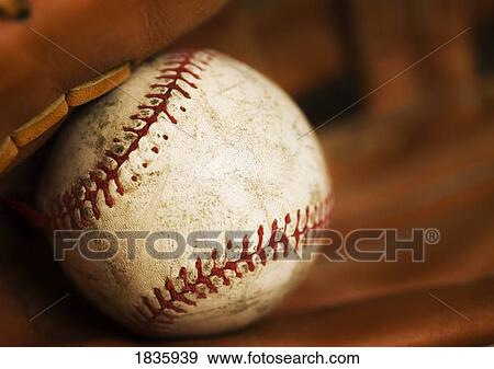 Stock Photo - Close up of a baseball in a glove. Fotosearch