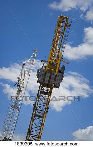 Stock Photography - Construction cranes against the sky . Fotosearch