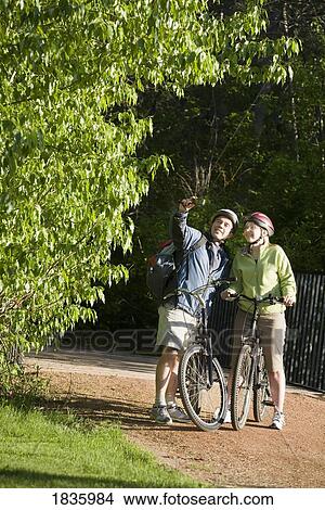 Picture - Couple biking together. Fotosearch