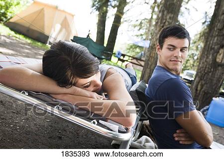 Couple relaxing at their campsite View Large Photo Image Stock Image - Couple relaxing at their campsite. Fotosearch