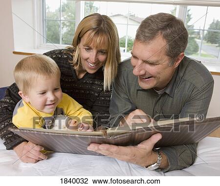 Family looking at a photo album View Large Photo Image Stock Image - Family looking at a photo album. Fotosearch