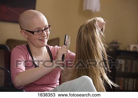 Stock Image - Girl brushing wig. Fotosearch