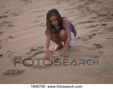 Girl drawing heart in the sand View Large Photo Image Stock Image - Girl drawing heart in the sand. Fotosearch