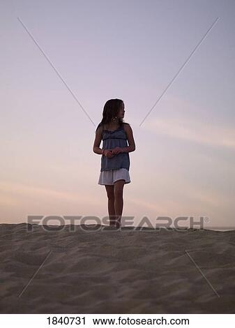 Stock Image - Girl standing on the beach. Fotosearch