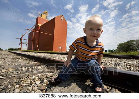 Stock Photo - Lake Lenore, Saskatchewan, Canada; boy on railroad tracks. Fotosearch