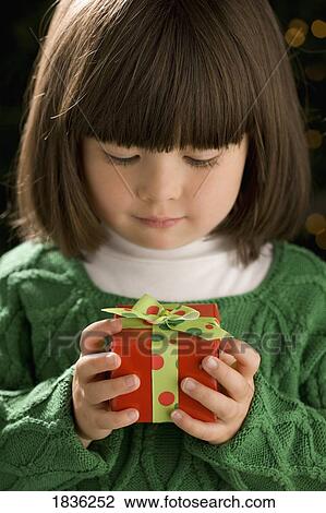 Stock Image - Little girl holding a present. Fotosearch