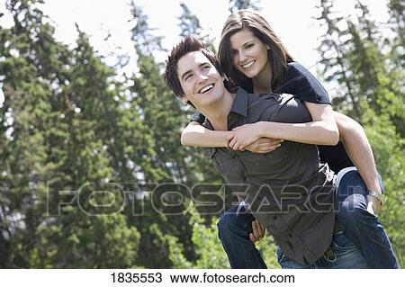Man carrying woman on his back View Large Photo Image Stock Image - Man carrying woman on his back. Fotosearch