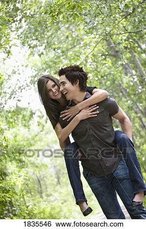 Stock Photograph - Man carrying woman on his back. Fotosearch