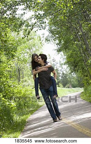 Stock Photography - Man giving woman a ride on his back. Fotosearch