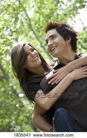 Stock Photo - Man giving woman ride on his back. Fotosearch
