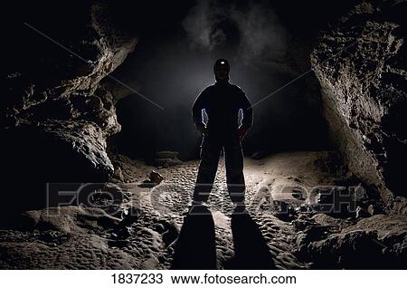 Stock Image - Man in a cave. Fotosearch