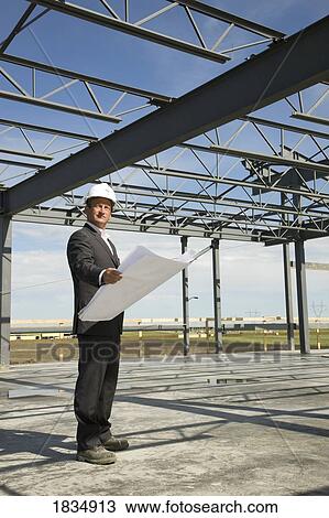 Man looking at architectural drawings View Large Photo Image Stock Image - Man looking at architectural drawings. Fotosearch
