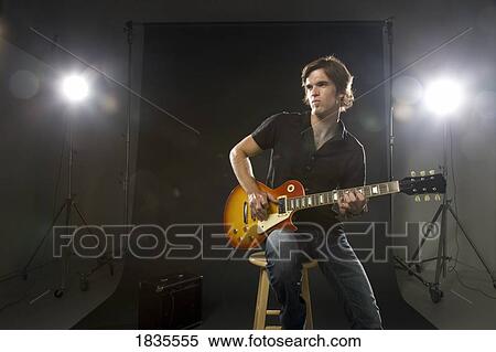 Man playing guitar in studio View Large Photo Image Stock Photography - Man playing guitar in studio. Fotosearch