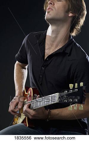 Man playing guitar View Large Photo Image Stock Photograph - Man playing guitar. Fotosearch