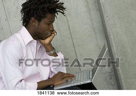 Stock Photo - Man working on laptop. Fotosearch