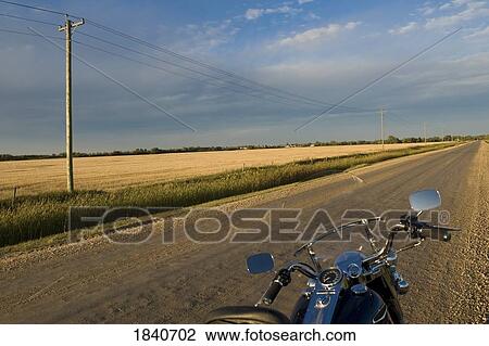 Stock Image - Motorcycle on a prairie road, Manitoba, Canada. Fotosearch