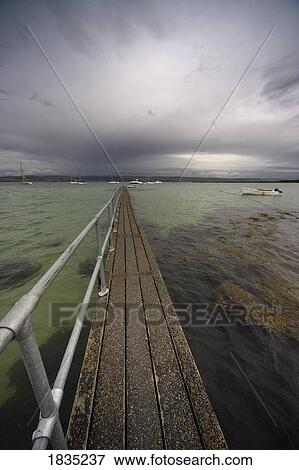 Pier extending out in to the water View Large Photo Image Stock Photo - Pier extending out in to the water. Fotosearch
