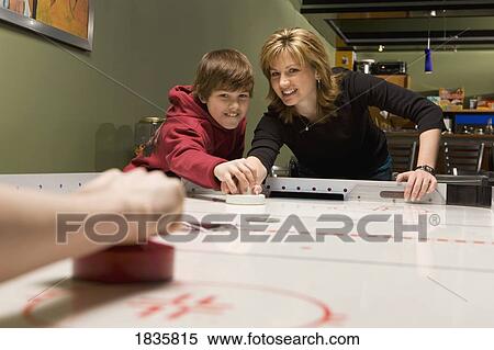 Stock Photography - Playing a game of air hockey. Fotosearch