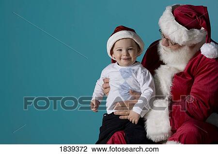 Stock Image - Santa holding a child. Fotosearch