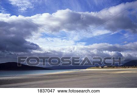 Stock Photo - Seilebost, Isle of Harris, Scotland; Clouds breaking through the clouds over a beach. Fotosearch