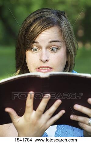 Picture - Shocked woman reading book . Fotosearch