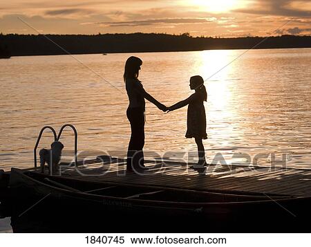 Silhouette of mother and daughter on a dock, Lake of the Woods, Ontario, Canada View Large Photo Image Stock Photography - Silhouette of mother and daughter on a dock, Lake of the Woods, Ontario, Canada. Fotosearch