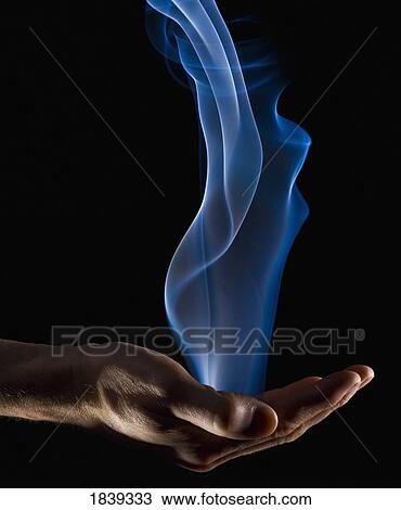 Stock Image - Smoke wisps from a hand. Fotosearch