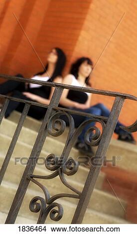 Two women sitting on stairs View Large Photo Image Picture - Two women sitting on stairs. Fotosearch