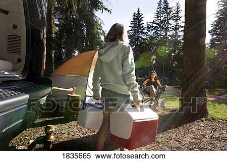 Stock Photography - Unloading camping supplies. Fotosearch
